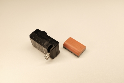 Comes with 2x unoriginal Canon LP-E6 batteries.Comes with UK style Canon LP-E6 charger.